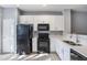 Well-lit kitchen featuring white cabinets, countertops and black appliances at 2605 Andros Ln, Kissimmee, FL 34747