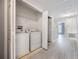 Bright laundry room features a washer, dryer, and shelving for organized storage solutions at 2605 Andros Ln, Kissimmee, FL 34747