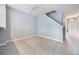 Inviting living room with gray flooring, a staircase, and bright neutral walls at 2605 Andros Ln, Kissimmee, FL 34747
