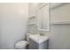 Small bathroom with toilet, sink, and floating shelves at 4006 Markham Pl, Orlando, FL 32814