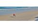 A scenic view of two men walking along the beach, with gentle ocean waves in the background at 4175 S Atlantic Ave # 232, New Smyrna Beach, FL 32169