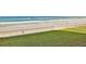 View of a beach from a balcony with grass and a retaining wall at 4175 S Atlantic Ave # 232, New Smyrna Beach, FL 32169