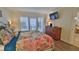 Bedroom featuring a dresser and a television, wood laminate floors and shuttered doors to the balcony at 4175 S Atlantic Ave # 232, New Smyrna Beach, FL 32169