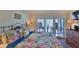 Bedroom featuring a balcony with a view, colorful linens, and a television at 4175 S Atlantic Ave # 232, New Smyrna Beach, FL 32169
