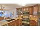 Kitchen featuring custom wood cabinets, stainless steel appliances, and tile backsplash at 4175 S Atlantic Ave # 232, New Smyrna Beach, FL 32169