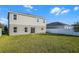 A view of the back exterior with a well-maintained lawn, featuring a two-story home at 514 Eagle Landing Blvd, Winter Haven, FL 33880