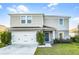 Charming two-story home featuring a blue front door, a two car garage, and manicured lawn at 514 Eagle Landing Blvd, Winter Haven, FL 33880