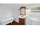 Charming bathroom featuring a clawfoot tub and a wood vanity with elegant mirror at 632 Tildenville School Rd, Winter Garden, FL 34787