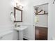 Cozy bathroom features pedestal sink, wood trim and view to vaulted bedroom at 632 Tildenville School Rd, Winter Garden, FL 34787