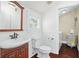 Cozy bathroom with wood vanity, toilet, and view into the laundry room at 632 Tildenville School Rd, Winter Garden, FL 34787