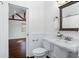 Cozy bathroom with a pedestal sink, wainscoting, and access to the bedroom at 632 Tildenville School Rd, Winter Garden, FL 34787