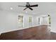 Spacious living room featuring dark wood floors, white walls, ceiling fan, and natural light from multiple windows at 632 Tildenville School Rd, Winter Garden, FL 34787