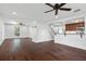 Open-concept living space featuring dark wood floors, white walls, ceiling fans and a view into the kitchen at 632 Tildenville School Rd, Winter Garden, FL 34787