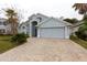 Charming single-story home featuring a well-manicured lawn, brick-paved driveway, and a two-car garage at 742 Seneca Meadows Rd, Winter Springs, FL 32708