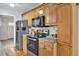 Bright kitchen featuring wooden cabinetry, stainless steel appliances, and hardwood floors at 783 Cornelia Ct, Orlando, FL 32811