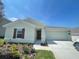 One-story home with light green exterior, landscaping, and attached garage at 1148 Pomelo St, Davenport, FL 33837