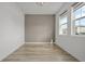 Bright bedroom with wood-look flooring, a gray accent wall, and natural light from two windows at 11842 Sunsail Ave, Orlando, FL 32832