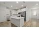 Modern kitchen boasts white cabinets, a center island, and stainless steel appliances at 11842 Sunsail Ave, Orlando, FL 32832