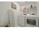 Bright laundry room with a modern washer, dryer, ironing board, and laundry-themed wall decor at 11842 Sunsail Ave, Orlando, FL 32832