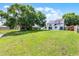 A spacious backyard with lush green grass, solar panels, and mature trees at 119 Floral Ct, Kissimmee, FL 34743