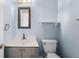 Bathroom features a vintage mirror, single vanity, toilet, and light blue paint at 119 Floral Ct, Kissimmee, FL 34743