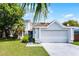 Inviting home featuring lush landscaping, a spacious two-car garage, and a well-maintained front yard at 119 Floral Ct, Kissimmee, FL 34743