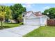 Charming home showcasing a spacious driveway, a two-car garage, and a beautifully maintained lawn at 119 Floral Ct, Kissimmee, FL 34743