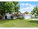 Well-manicured lawn with an elegant home featuring a two-car garage and mature shade trees at 119 Floral Ct, Kissimmee, FL 34743