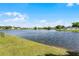 A scenic lake view surrounded by lush green grass and mature trees on a sunny day at 119 Floral Ct, Kissimmee, FL 34743