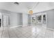 Spacious living room with white tile floors, modern light fixture, and plenty of natural light at 119 Floral Ct, Kissimmee, FL 34743
