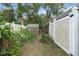 Backyard featuring lush greenery, a greenhouse, and a white privacy fence at 1221 Thunder Trl, Maitland, FL 32751