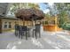 Outdoor entertaining area featuring a tiki bar, grill, and a wooden bar structure with seating at 1221 Thunder Trl, Maitland, FL 32751