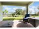 A covered back patio offers outdoor seating and serene views of the fenced backyard and a tranquil pond at 13557 Parkfield Way, Winter Garden, FL 34787