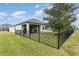 The backyard features a covered patio and a black metal fence for security at 13557 Parkfield Way, Winter Garden, FL 34787