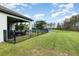 Expansive backyard with a covered patio, iron fence, and tranquil water view at 13557 Parkfield Way, Winter Garden, FL 34787