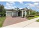 Inviting single-story home featuring a well-maintained front yard and brick-paved driveway leading to a two-car garage at 13557 Parkfield Way, Winter Garden, FL 34787