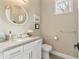 Charming powder room features a white vanity, round mirror, and neutral color palette at 15138 Shonan Gold Dr, Winter Garden, FL 34787