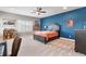 Bedroom with a blue accent wall, decorative ceiling fan, and light gray furniture at 15138 Shonan Gold Dr, Winter Garden, FL 34787