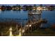 Illuminated dock at night on a serene lake, creating a magical ambiance and inviting waterfront experience at 15138 Shonan Gold Dr, Winter Garden, FL 34787
