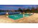Twilight view of a luxurious pool area with fire features, offering a serene escape by the lake at 15138 Shonan Gold Dr, Winter Garden, FL 34787