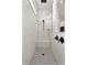Modern shower with a black shower head, white tiling and black and white tiled flooring at 15138 Shonan Gold Dr, Winter Garden, FL 34787