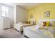 Bedroom with two twin beds, yellow walls and cheerful decor at 1534 Tranquil Ave, Clermont, FL 34714