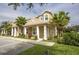 Tan two-story house with white columns and palm trees in front at 1534 Tranquil Ave, Clermont, FL 34714
