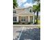 Tan two-story townhome with white columns, landscaping, and parking at 1534 Tranquil Ave, Clermont, FL 34714