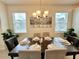 Formal dining room with seating for six, decorative chandelier, and sunlit windows at 1700 Tropical Palms Cir, Kissimmee, FL 34747