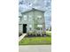 Modern two-story home with stone accents, green facade, and well-maintained landscaping at 1700 Tropical Palms Cir, Kissimmee, FL 34747