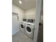 Well-organized laundry room with washer, dryer, wire rack, and tile flooring at 1700 Tropical Palms Cir, Kissimmee, FL 34747