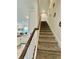 Carpeted stairs with a wooden railing leading to the upper level of the home at 1700 Tropical Palms Cir, Kissimmee, FL 34747