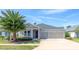 Charming single-story home with a well-manicured lawn, two-car garage, and a beautiful palm tree in the front yard at 17680 Passionflower Cir, Clermont, FL 34714