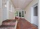 Covered back porch with brick flooring, white doors, a grilling area and access to the backyard at 2004 Magnolia Ave, Sanford, FL 32771
